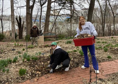 two members of the delta gamma sorority house working in the sensory garden with master gardener Frank Male